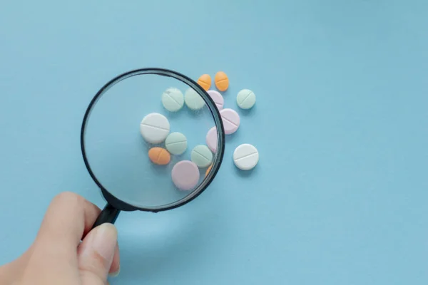 Lente Ingrandimento Con Pillole Sfondo Blu Ispezione Farmaceutica Identifica Pillole — Foto Stock