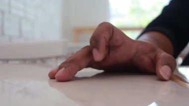 Adam el parmağı masaya vuruyor..
