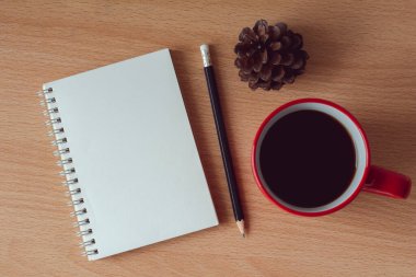 Beyaz arka planda kırmızı kahve kupası olan boş kağıt defter..