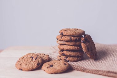 Kahverengi arka planda çikolata parçacıklı kurabiyeler.