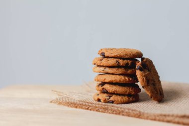 Kahverengi arka planda çikolata parçacıklı kurabiyeler.