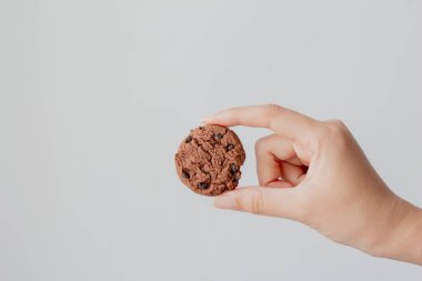 Kadın eli çikolatalı kurabiye arka planda. 