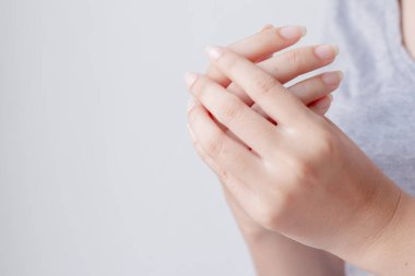 Ellerindeki acıdan muzdarip genç bir kadın ve acı çeken ellerine masaj yapıyor. Sağlık ve tıbbi konsept.