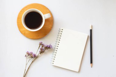 Düz kahve yatağı ve beyaz arkaplan üzerine defter ve kopyalama alanı.