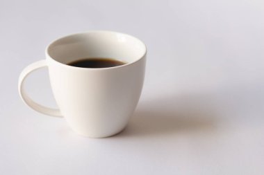 Ahşap sehpanın üzerinde beyaz duvar zemininde kopya alanı olan beyaz kahve fincanı.