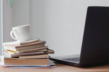 Ofis masasında yığınla belge ve dizüstü bilgisayarlı bir fincan kahve. Boşluğu kopyala.