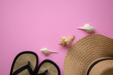 Plaj aksesuarları, not defterli hasır şapka, pastel pembe arka planda deniz kabuğu, yaz tatili ve tatil konsepti..
