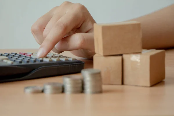 Kobieta Ręka Używać Kalkulator Stosem Monet Skrzynki Paczki Obliczanie Dochodu — Zdjęcie stockowe