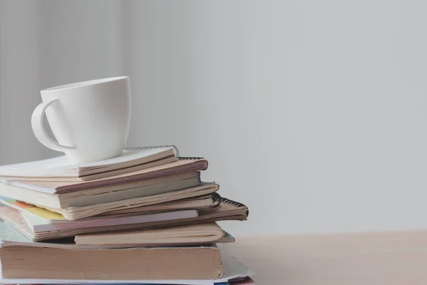 Ofis masasında yığın halinde bir fincan kahve. Boşluğu kopyala.