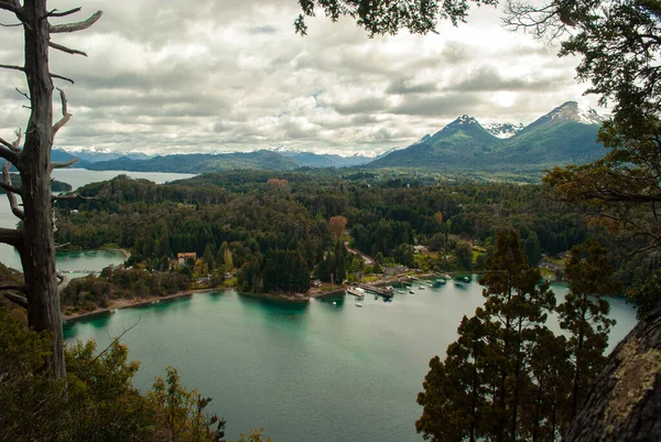 Bulutlu bir bahar gününde gölün ve ormanın kıyılarının burun dalış manzarası