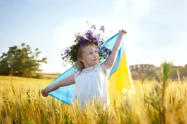 Mavi bir arka planda sarı ve mavi bir bayrak ve altın bir buğday tarlası olan mutlu bir Ukraynalı kız. Ukrayna 'nın Bağımsızlık Günü. Ukrayna Ulusal Bayrak Günü. Anayasa günü. sembol