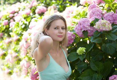 Çiçek açan ortanca bahçesinde güzel bir kız