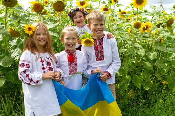 Czworo Pięknych Uśmiechniętych Dzieci Haftowanych Koszulach Trzyma Żółtą Niebieską Flagę — Zdjęcie stockowe