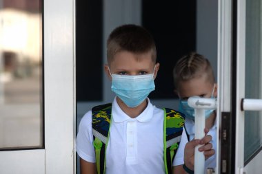 Okula dönelim. Okul çocukları okul kapısından maske takarak gelir. Çocuk salgın hastalık üstüne okula gidiyor. Öğrenciler yeni yıla hazır..