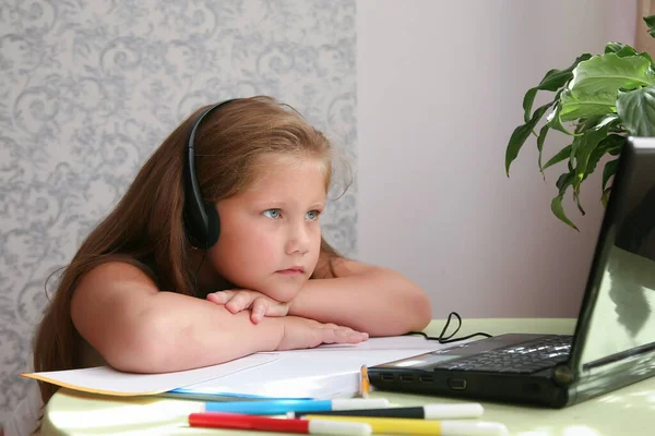 Focused kid self isolation wearing headphones using laptop in cafe, writing notes,student girl learning language, watching online webinar, Home schooling, e-learning education concept