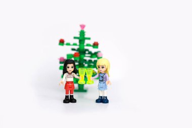 Kyiv, Ukrayna - 25 Eylül 2020: Lego minyatürleri - Kızlar yeni yıl ağacının arka planında şampanya içerler. Noel içkisi. Lego kavramı