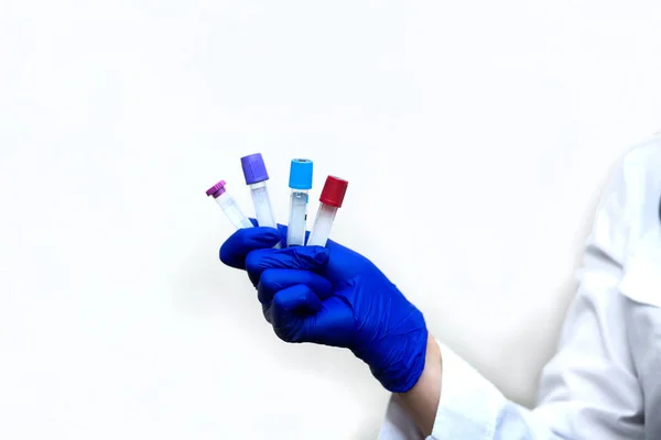 Doctor / laboratory technician hands in medical gloves holding test tubes for patient samples of coronavirus tests. Nasal swab laboratory test in hospital lab.