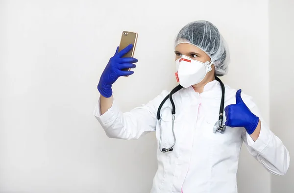 Doctor woman with stethoscope, glasses isolated on white background. Female doctor in medical gown doing selfie on mobile phone. Healthcare personnel, health, medicine