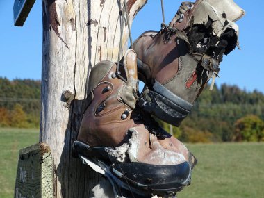 The hiking boots are worn now. clipart