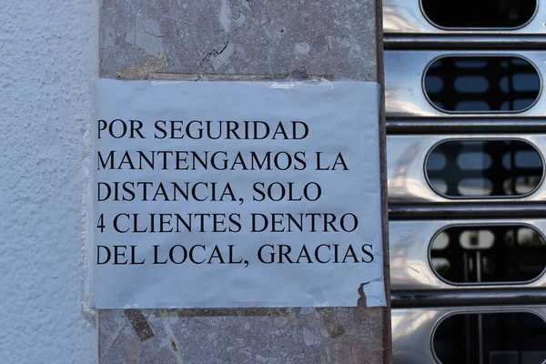 İspanyolca bir mağazanın vitrininde covid-19 hakkında uyarı ve tavsiye afişi