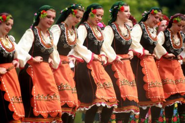 Varvara, Bulgaristan - 5 Mayıs 2015: Geleneksel kostümlü insanlar Varvara köyü yakınlarında bir çayır olan Bulgar horosuyla dans ediyorlar