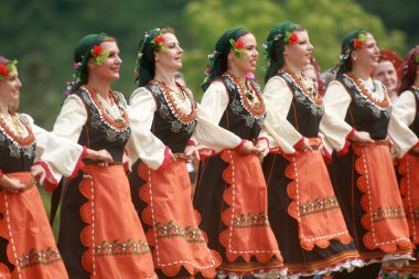 Varvara, Bulgaristan - 5 Mayıs 2015: Geleneksel kostümlü insanlar Varvara köyü yakınlarında bir çayır olan Bulgar horosuyla dans ediyorlar