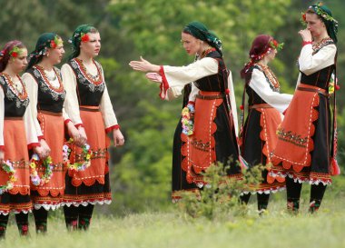 Varvara, Bulgaristan - 5 Mayıs 2015: Geleneksel kostümlü insanlar Varvara köyü yakınlarında bir çayır olan Bulgar horosuyla dans ediyorlar