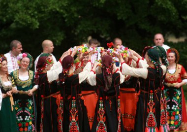 Varvara, Bulgaristan - 5 Mayıs 2015: Geleneksel kostümlü insanlar Varvara köyü yakınlarında bir çayır olan Bulgar horosuyla dans ediyorlar