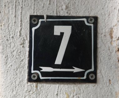 Eski model, kare, paslı, paslı bir plaka. Adres numarası da var. Yaklaş, marka..