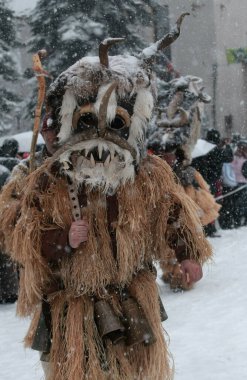 Breznik, Bulgaristan - 16 Ocak 2016: Bulgaristan 'ın Breznik kentinde düzenlenen Maskeli Balo Festivali' nde geleneksel Kukeri kostümlü kimliği belirsiz kişiler görülüyor.