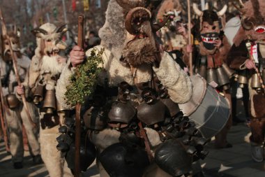 Pernik, Bulgaria - January 30, 2016 - Masquerade festival Surva in Pernik, Bulgaria. People with mask called Kukeri dance and perform to scare the evil spirits. clipart