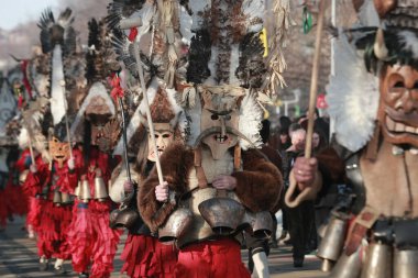 Pernik, Bulgaria - January 30, 2016 - Masquerade festival Surva in Pernik, Bulgaria. People with mask called Kukeri dance and perform to scare the evil spirits. clipart