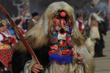 Pernik, Bulgaristan - 27 Ocak 2019: Kukeri isimli maskeli kişiler, Pernik kentinde düzenlenen Uluslararası Maskeli Balo Oyunları Surva Festivali 'nde kötü ruhları korkutmak ve dans etmek için gösteri yapıyorlar, 