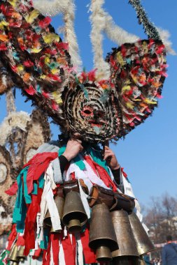Pernik, Bulgaristan - 28 Ocak 2019: Bulgaristan 'ın Pernik kentinde düzenlenen Uluslararası Maskeli Oyunlar Festivali' nde Kukeri adlı maskeli insanlar dans ediyor ve kötü ruhları korkutmak için gösteri yapıyorlar.