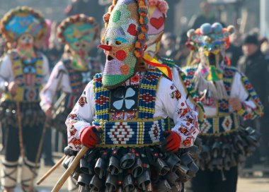 Pernik, Bulgaristan - 28 Ocak 2019: Bulgaristan 'ın Pernik kentinde düzenlenen Uluslararası Maskeli Oyunlar Festivali' nde Kukeri adlı maskeli insanlar dans ediyor ve kötü ruhları korkutmak için gösteri yapıyorlar.