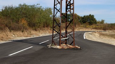 Yolun ortasında elektrik direği var.