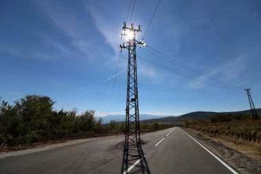 Yolun ortasında elektrik direği var.