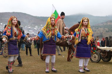 Velingrad, Bulgaristan - 24 Şubat 2018: Geleneksel kostümlü insanlar Velingrad yakınlarındaki bir çayır, At Paskalyası olarak da bilinen geleneksel Todorov Günü 'nde şarkı söyleyip dans ediyorlar.