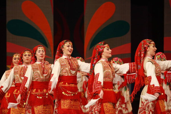 Sofia, Bulgaria - February 4, 2009: People in traditional folklore costumes perform folk dance bulgarian horo on National folklore fair in the Sofia, Bulgaria
