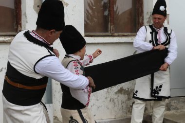 Zemen, Bulgaristan - 16 Mart 2019: Geleneksel Bulgar özgün folklor kıyafetleriyle giyinen insanlar Bulgaristan 'ın Zemen kentinde tatil yapıyorlar