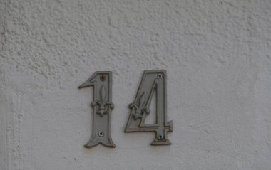 Eski model, kare, paslı, paslı bir plaka. Adres numarası da var. Yaklaş, marka.