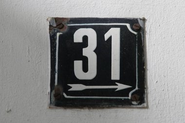 Eski model, kare, paslı, paslı bir plaka. Adres numarası da var. Yaklaş, marka.