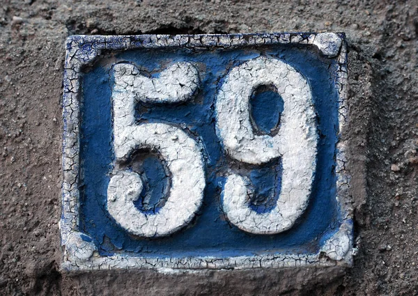 Eski model, kare, paslı, paslı bir plaka. Adres numarası da var. Yaklaş, marka.