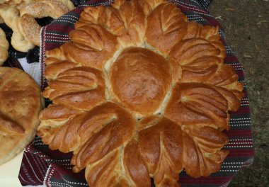 Geleneksel Bulgar tekstil ürünlerinde taze pişmiş ev yapımı ekmek. Lezzetli ev yapımı fırın ürünlerinin görüntüsü.
