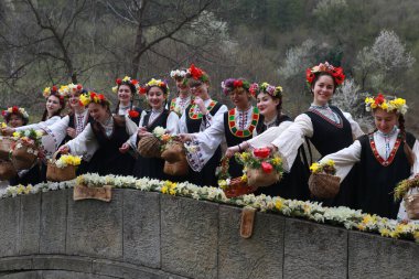 Gabrovo, Bulgarya- 8 Nisan 2017: Kızlar saçlarını renkli ve zengin bir şekilde dekore ediyor ve köyde şarkı söyleyip dans ediyorlar, bu şekilde evlenmeye hazır olduklarını gösteriyorlar.