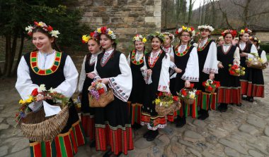 Gabrovo, Bulgarya- 8 Nisan 2017: Kızlar saçlarını renkli ve zengin bir şekilde dekore ediyor ve köyde şarkı söyleyip dans ediyorlar, bu şekilde evlenmeye hazır olduklarını gösteriyorlar.