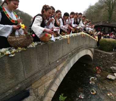 Gabrovo, Bulgarya- 8 Nisan 2017: Kızlar saçlarını renkli ve zengin bir şekilde dekore ediyor ve köyde şarkı söyleyip dans ediyorlar, bu şekilde evlenmeye hazır olduklarını gösteriyorlar.