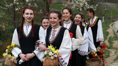 Gabrovo, Bulgarya- 8 Nisan 2017: Kızlar saçlarını renkli ve zengin bir şekilde dekore ediyor ve köyde şarkı söyleyip dans ediyorlar, bu şekilde evlenmeye hazır olduklarını gösteriyorlar.