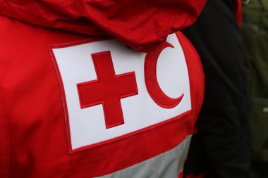 Üniforma üzerinde Kızıl Haç ve Kızıl Hilal sembolü olan detaylar. Kızıl Haç ve Kızıl Hilal, savaş veya doğal afet kurbanlarına yardım sağlayan uluslararası insani kuruluşlardır.