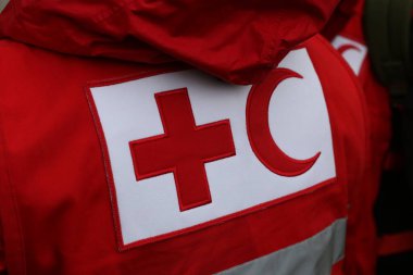 Üniforma üzerinde Kızıl Haç ve Kızıl Hilal sembolü olan detaylar. Kızıl Haç ve Kızıl Hilal, savaş veya doğal afet kurbanlarına yardım sağlayan uluslararası insani kuruluşlardır.
